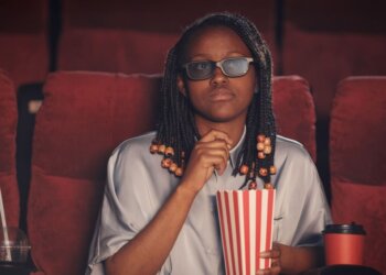 An African woman watching a movie in the cinemas.