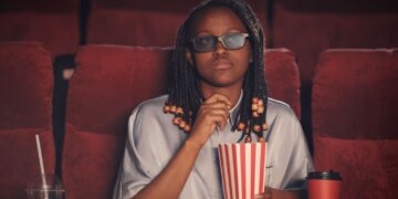 An African woman watching a movie in the cinemas.